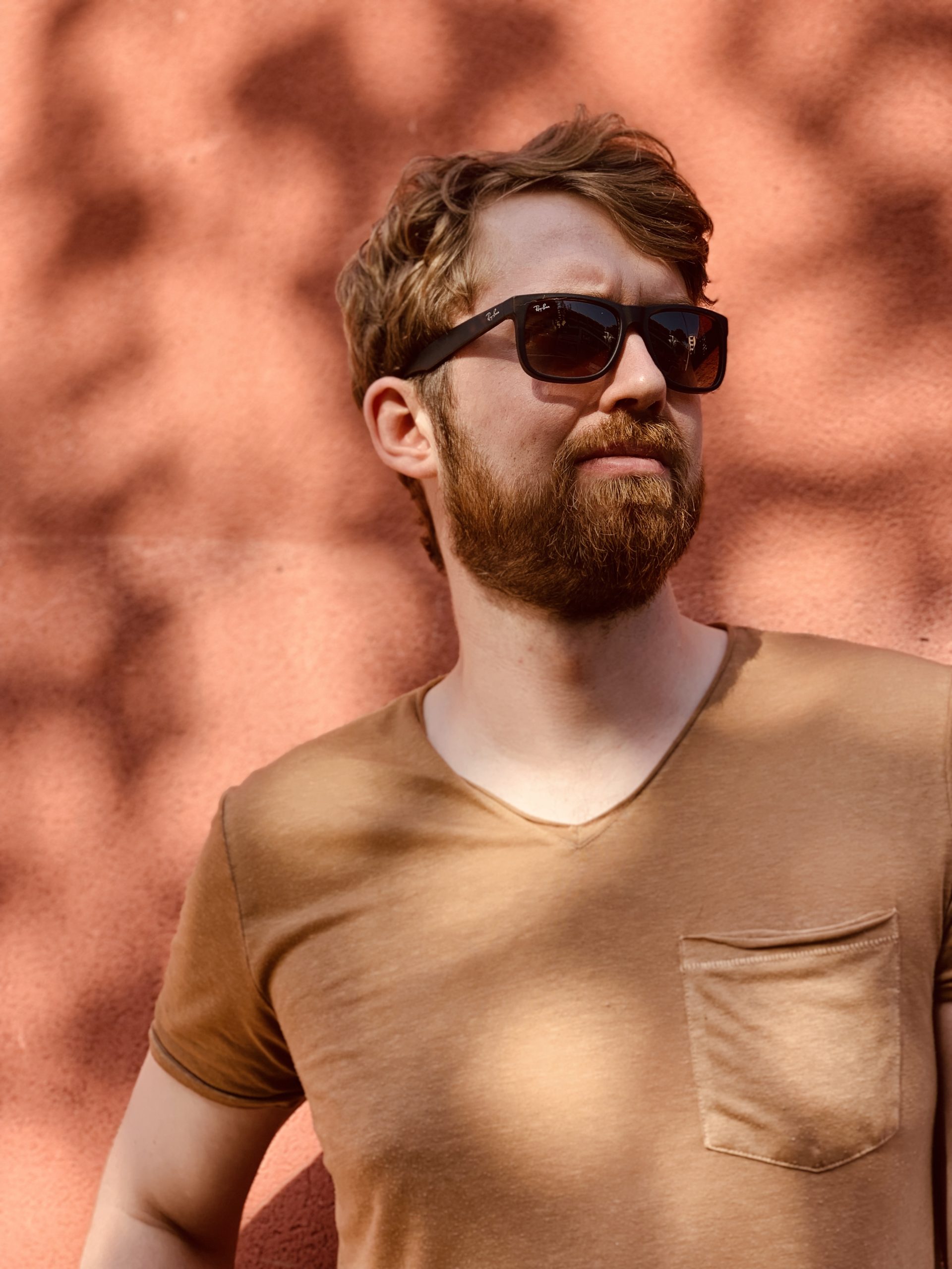 man in front of wall orange shadow