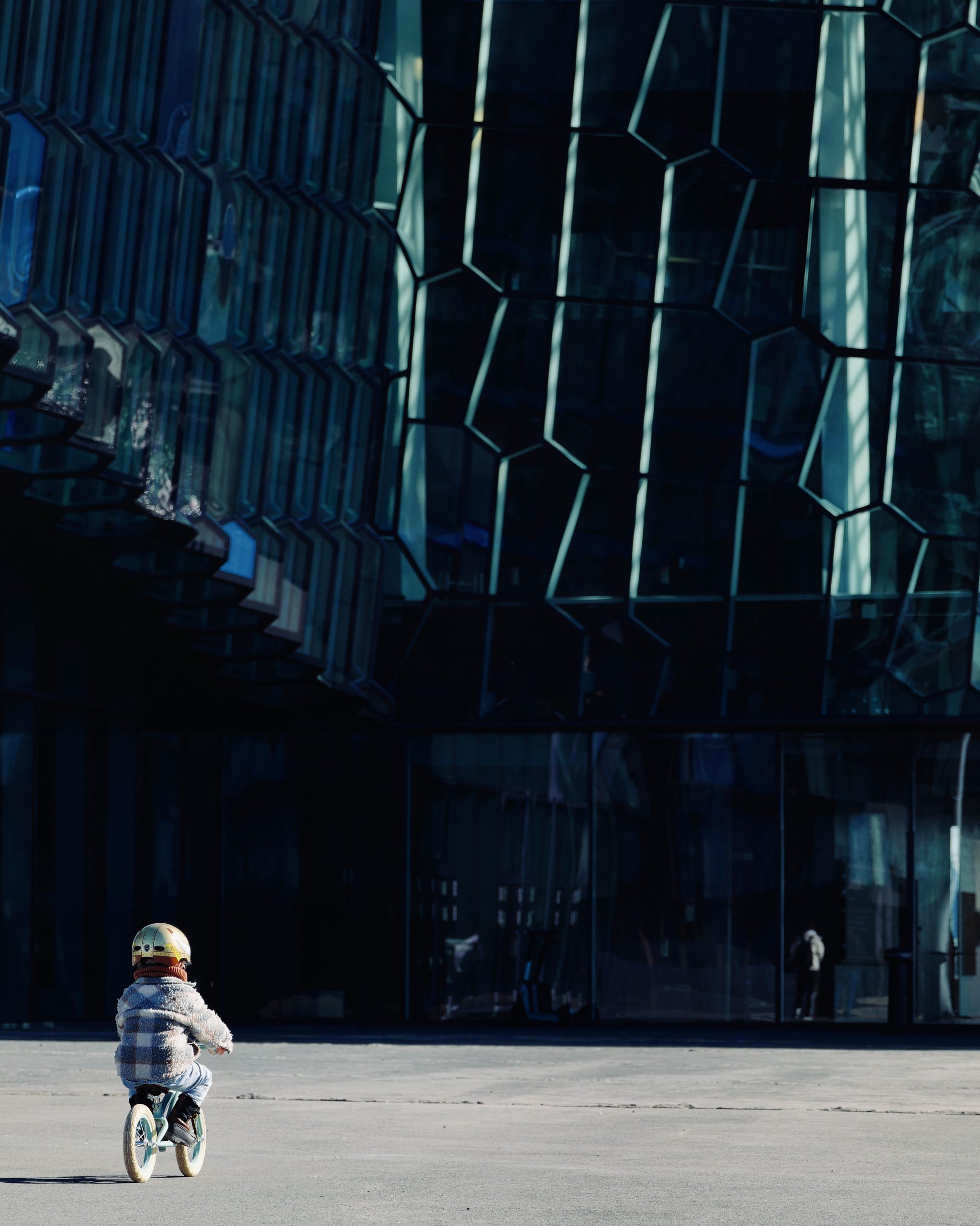 boy cycling in front of harpa